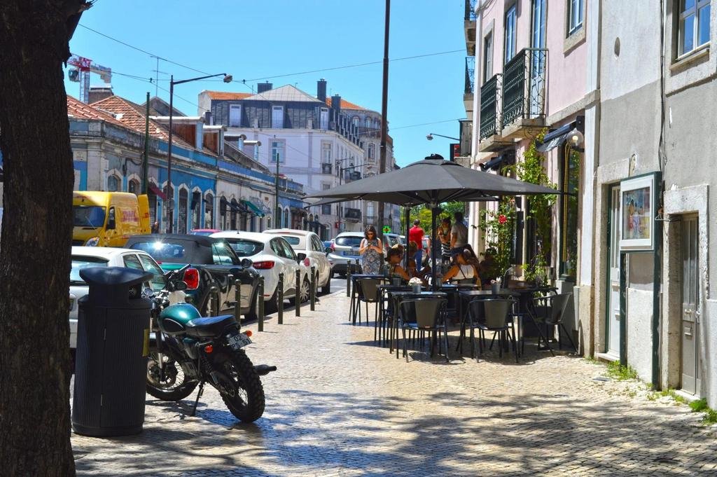 A café terrace on a cobbled street in Príncipe Real, Lisbon, Portugal, a neighbourhood popular with Americans who have moved to Lisbon