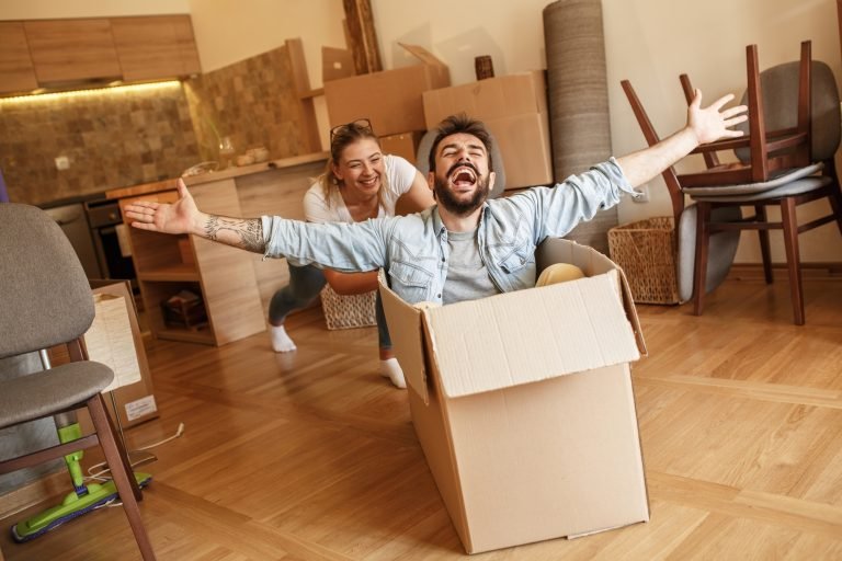 A couple unpacking moving boxes in their new home in Portugal after moving, while their fiscal representation is switched to their Portuguese address