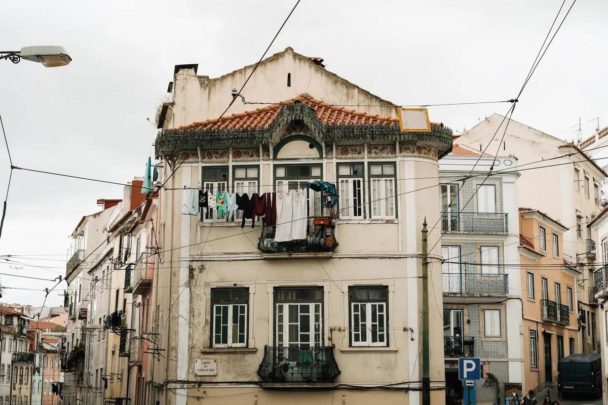 A lived-in apartment building in Lisbon, Portugal with laundry hanging from a balcony, a home kept as a habitual base for tax residency