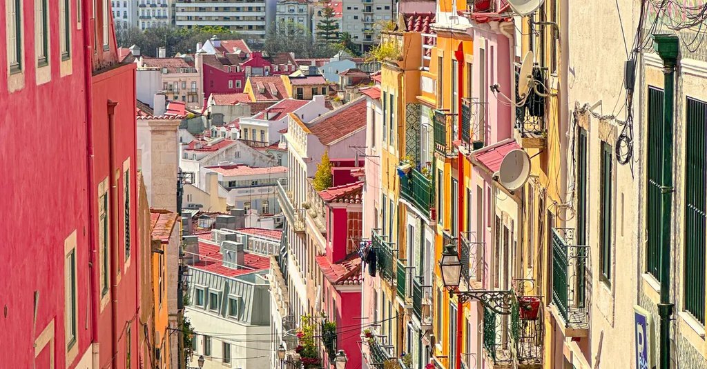 Colourful apartment buildings on a steep residential street in Lisbon, Portugal, where many overseas buyers purchase a city apartment with a Portuguese NIF