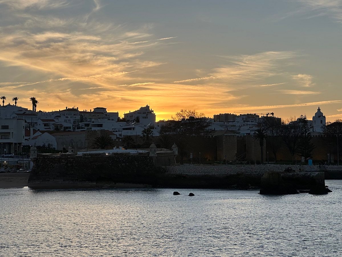 Lagos old town and the Forte da Ponta da Bandeira in the Algarve, Portugal, at sunset, a coast where many Canadian snowbirds and retirees buy homes and need a NIF