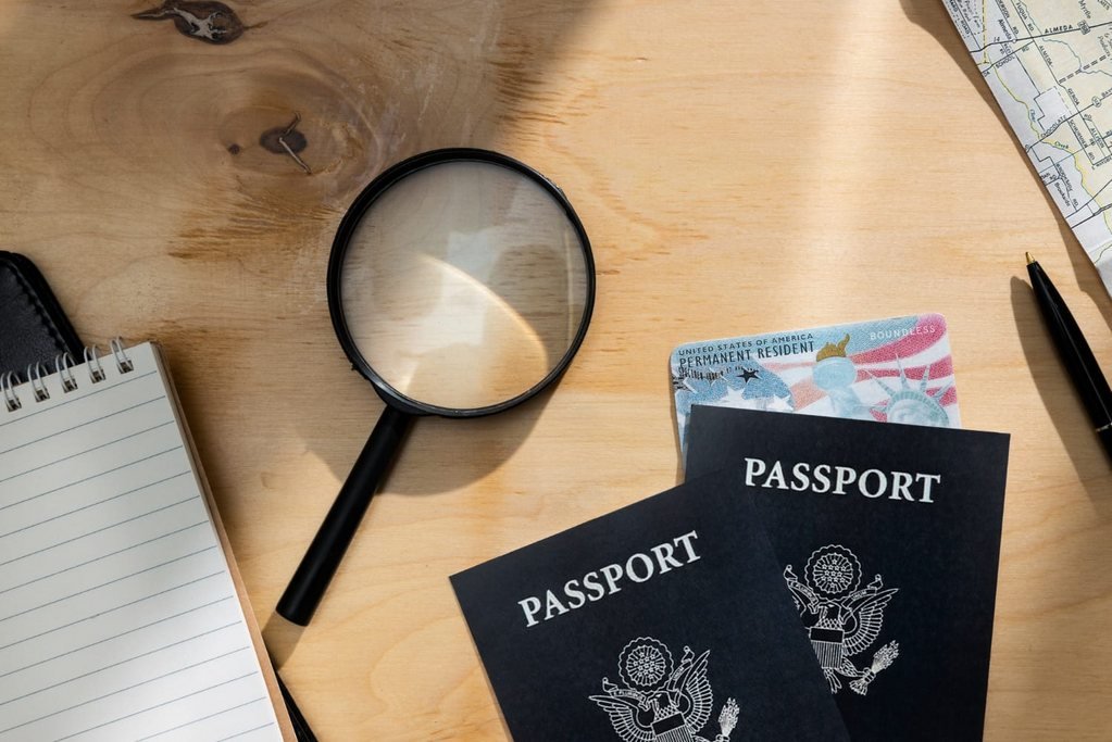 Passports, an ID card, a notebook and a magnifying glass on a desk, the documents prepared for a Portuguese NIF application from abroad